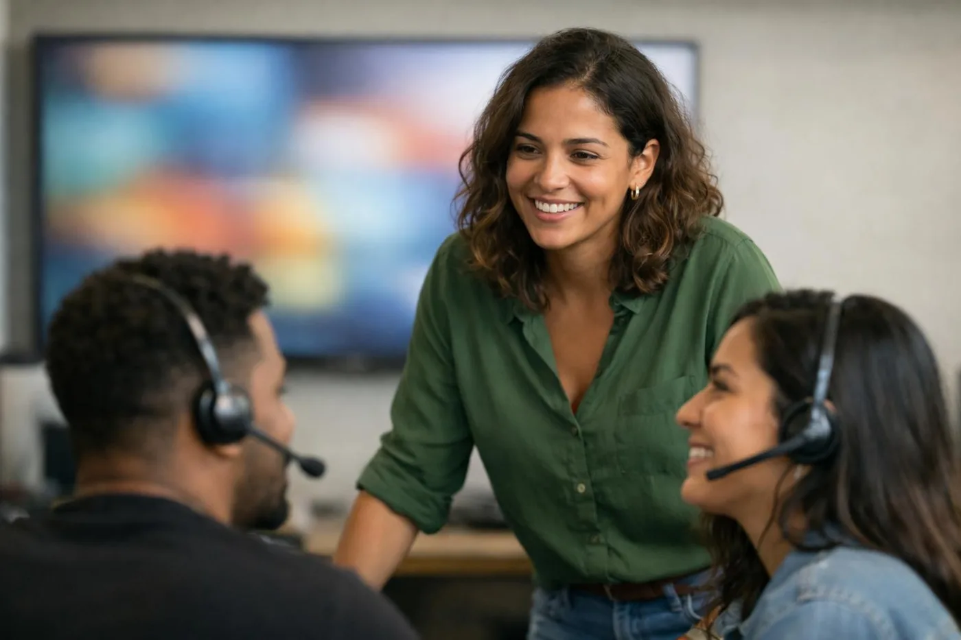 Supervisora analisando resultados da operação em um monitor ao lado da equipe