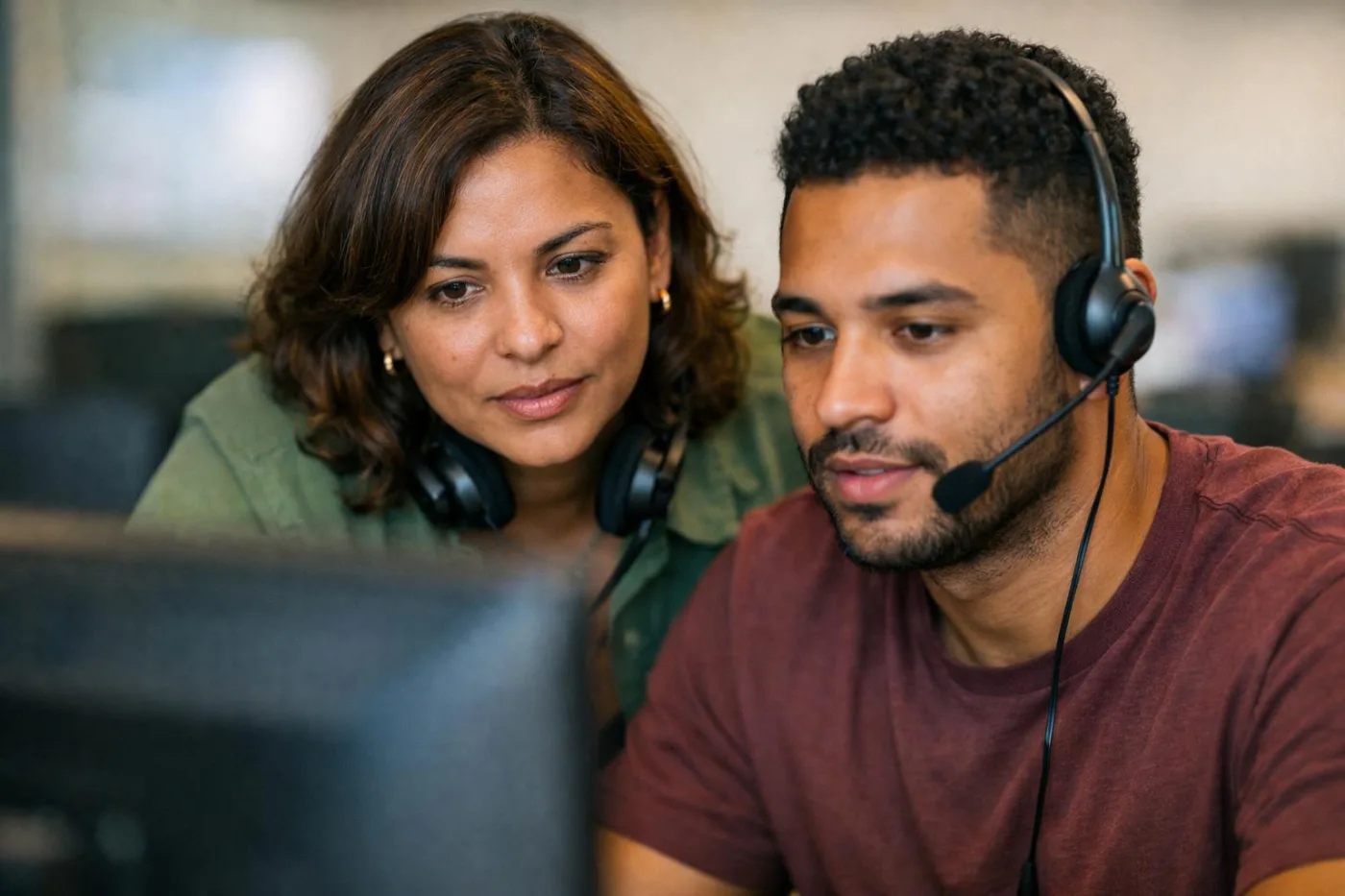 Supervisora revisando uma ligação com um operador diante do monitor
